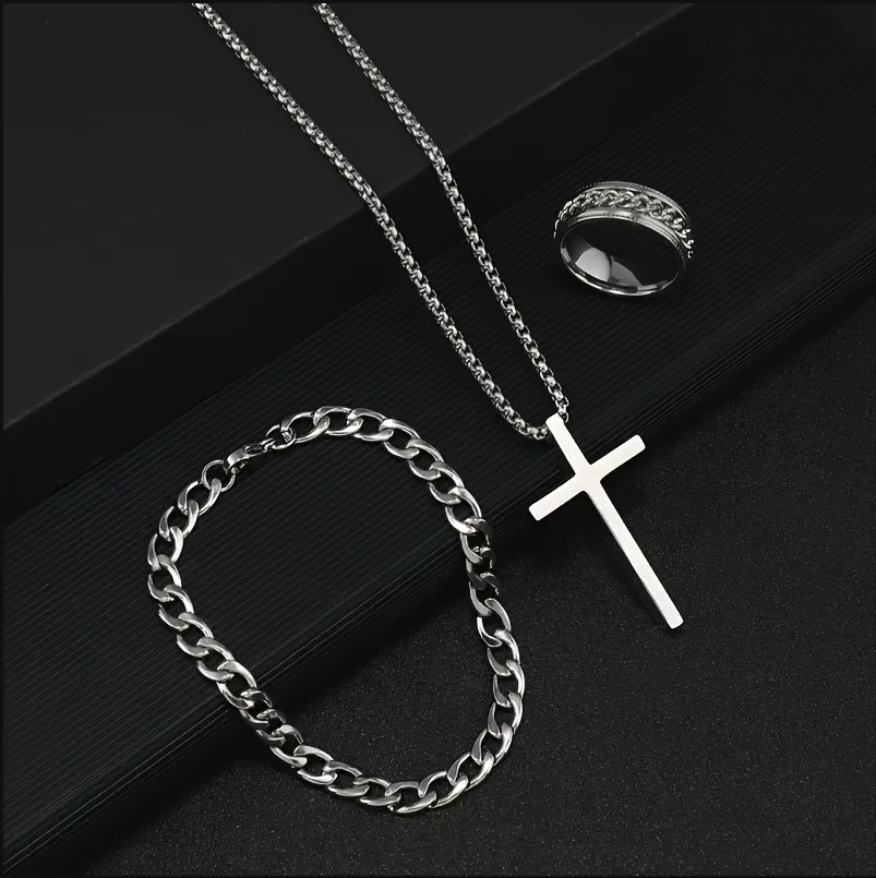 Silver necklace with cross pendant and chain on a dark surface